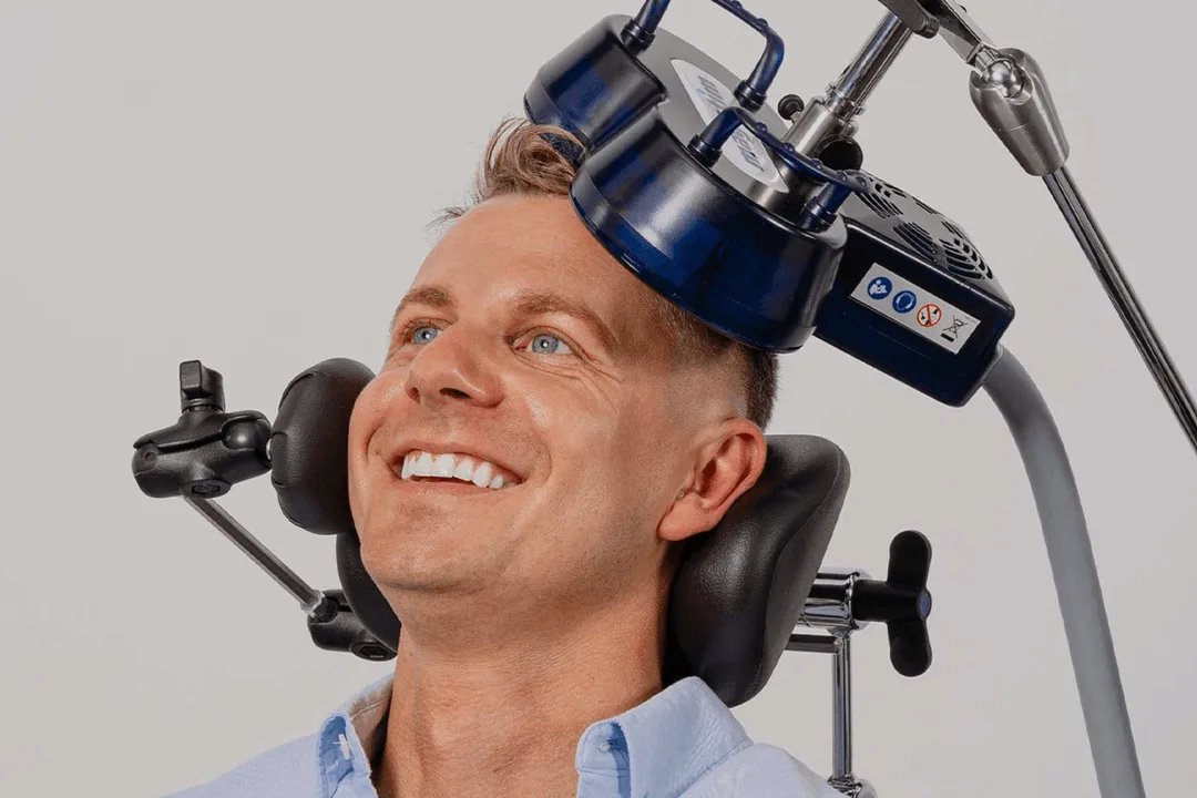 Smiling man receiving TMS treatment